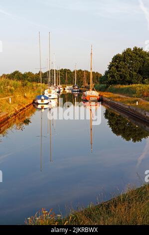 Vue sur les bateaux amarrés à Horsey Dyke avec réflexions et accès à Horsey Mere sur les Norfolk Broads à Horsey, Norfolk, Angleterre, Royaume-Uni. Banque D'Images