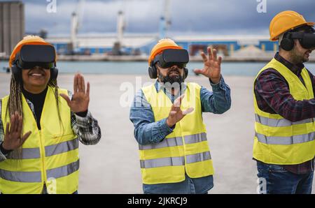 Travailleurs multiraciaux utilisant des micro-casques de réalité virtuelle au port du terminal de fret - concentrez-vous sur le visage de l'homme central Banque D'Images