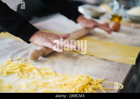 Femme préparant de la pâte pour les raviolis à l'intérieur de l'usine de pâtes - attention douce sur les doigts Banque D'Images