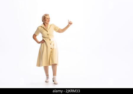 Portrait d'une belle femme âgée en tenue rétro de style vintage posant isolée sur fond blanc. Concept de beauté, vieille génération, mode Banque D'Images