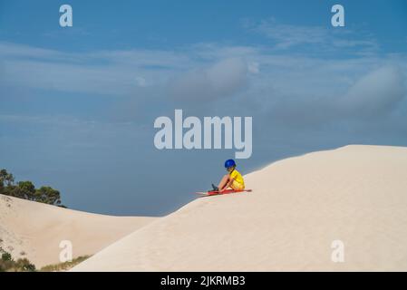 Boy est prêt à descendre la dune de sable sur le banc de sable, Kangaroo Island, Australie méridionale Banque D'Images