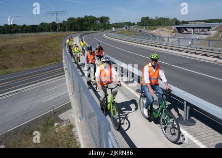 03 août 2022, Saxe, Rötha: Les cyclistes traversent un pont au-dessus de l'autoroute 72 près de Rötha. Alors que l'expansion de la dernière section des A72 continue à progresser, les B95 autour d'Espenhain sont actuellement démantelés. Une piste cyclable est actuellement en cours de construction entre Borna et Rötha, en utilisant en grande partie les voies existantes de l'ancienne B95 comme base. Les travaux sur la pièce maîtresse se poursuivront jusqu'à la mi-octobre. Ensuite, l'ancienne autoroute fédérale très fréquentée deviendra la route nationale 242 avec des bandes vertes bordées et de l'espace pour les piétons et les cyclistes. Photo: Hendrik Schmidt/dpa Banque D'Images