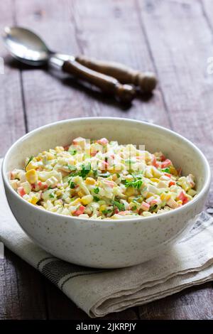 Salade de légumes avec bâtonnets de crabe, garnie de mayonnaise. Banque D'Images