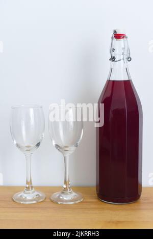 Vin prune maison avec verres sur fond blanc Banque D'Images