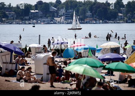 Berlin, Allemagne. 03rd août 2022. Les baigneurs s'attardent sur la plage de sable de Strandbad Wannsee. Avec des températures autour de 33 degrés, de nombreux visiteurs sont attirés par la piscine extérieure. Credit: Carsten Koall/dpa/Alay Live News Banque D'Images