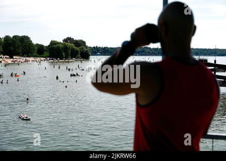 Berlin, Allemagne. 03rd août 2022. Un superviseur de natation observe les activités de baignade au Lido de Wannsee. Avec des températures autour de 33 degrés, de nombreux visiteurs sont attirés par la piscine extérieure. Credit: Carsten Koall/dpa/Alay Live News Banque D'Images