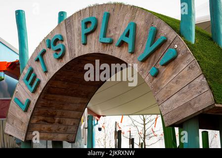 Panneau d'entrée en bois du terrain de jeu pour enfants let's Play. Banque D'Images