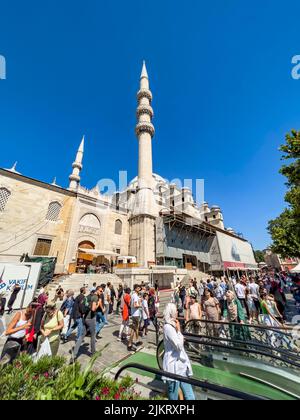 Istanbul, Turquie, 07.14.2022: Vue grand angle de la belle cour Yeni Cami Minaret (Nouvelle mosquée). Population locale bondée. Hommes musulmans et foulard hijab Banque D'Images