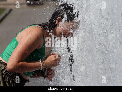 Berlin, Allemagne. 03rd août 2022. Une jeune femme ukrainienne profite de l'été dans la capitale allemande et se rafraîchit à des températures d'environ 35 degrés Celsius dans une fontaine de la ville dans le quartier de Mitte. Selon les météorologues, les températures continueront d'augmenter dans les jours à venir. Credit: Wolfgang Kumm/dpa/Alay Live News Banque D'Images