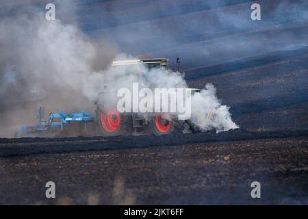 Hedersleben, Allemagne. 03rd août 2022. Un agriculteur plère une coupe-feu avec son tracteur dans un champ en feu. La sécheresse prolongée a parsèché le sol de sorte que les feux de champ peuvent être démarrés par une seule étincelle. Credit: Klaus-Dietmar Gabbert/dpa/Alay Live News Banque D'Images