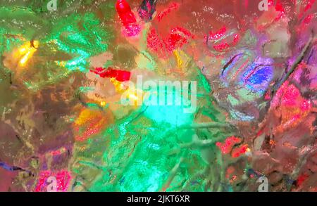 Lumières colorées visibles à travers le verre dépoli. Papier peint multicolore lumineux, abstrait et flou, avec espace de copie. Banque D'Images