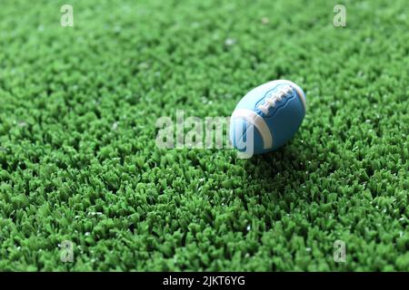 Image de mise au point sélective du ballon de rugby sur l'herbe de terrain de rugby avec espace de copie. Concept sport. Banque D'Images