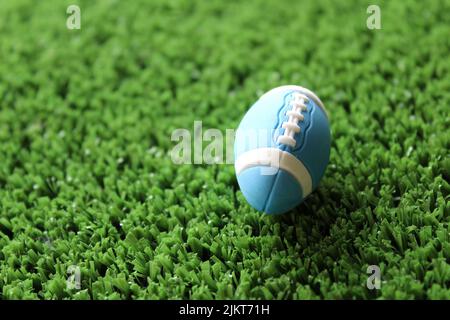 Image de mise au point sélective du ballon de rugby sur l'herbe de terrain de rugby avec espace de copie. Concept sport. Banque D'Images