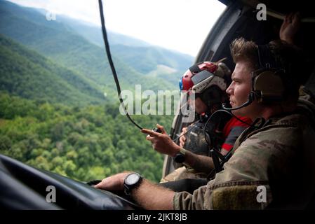 Un Airman de l’escadron tactique spéciale 123rd de la Garde nationale aérienne du Kentucky cherche des victimes d’inondations à partir d’un hélicoptère dans l’est du Kentucky sur 30 juillet 2022. En réponse à des inondations dévastatrices, l'unité a coordonné 29 missions de secours à voilure tournante, a secouru 19 personnes et deux chiens et a récupéré quatre corps. Leurs efforts de commandement et de contrôle ont également facilité l'assistance ou le rétablissement de 40 personnes. (É.-U. Photo de la Garde nationale aérienne par le sergent d'état-major. Vêtements Clayton) Banque D'Images