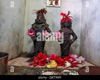 Khidrapur, Inde- 6 novembre 2021;photo de lord Vitthal et rakhumai idol sculptés en pierre noire dans le temple, les dévotés offrent fleurs, huile Banque D'Images