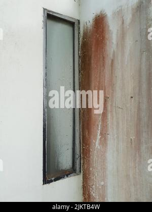 An old closed gray window in a room with white walls and brown colors made by a painting brush Stock Photo