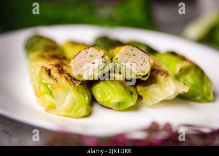 A closeup of stuffed cabbage rolls with minced meat on a white plate Stock Photo