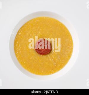 Polenta avec beurre et parmesan et saucisse de chorizo dans une assiette Banque D'Images