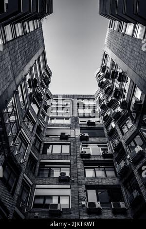 A low angle shot of a old stone building from courtyard in black and white Stock Photo