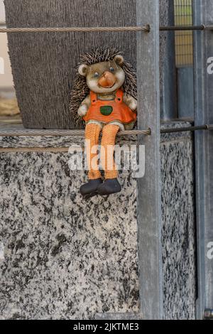 A vertical closeup of a hedgehog toy on the textured stone. Decoration of a house. Stock Photo