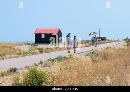 Réserve naturelle de Rye Harbour - touristes passant devant la cabane Red couved en été - Rye, East Sussex, Angleterre, Royaume-Uni Banque D'Images