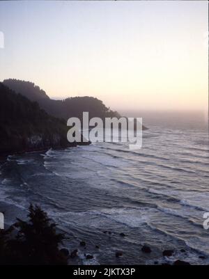 An aerial vertical shot of small waves breaking on rocks at the beach Stock Photo