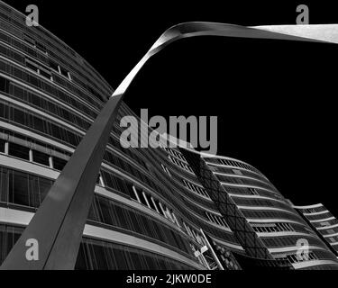 A low angle grayscale shot of a modern building with curvy architecture Stock Photo