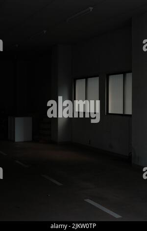 A dark empty store with grunge white walls with turned off lamps and white signs on the ground Banque D'Images