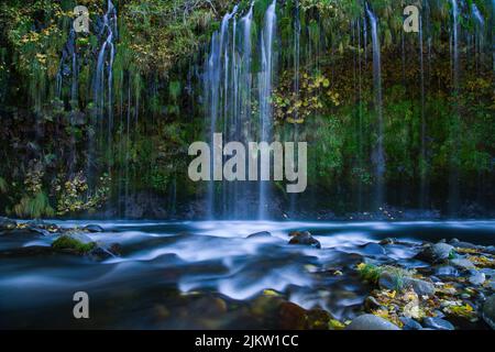 A mesmerizing view of the waterfall captured in the evening in the forest Stock Photo