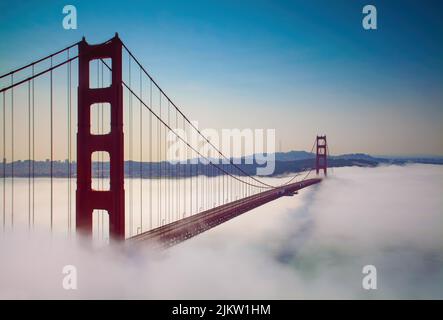 Le ciel bleu dégradé au-dessus du Golden Gate Bridge rouge, San Francisco, lors d'une soirée brumeuse Banque D'Images