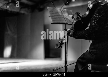 A greyscale shot of a violinist with the violin Stock Photo