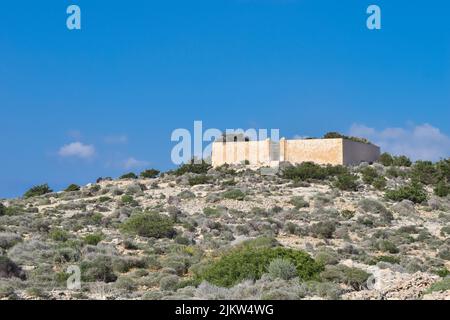 Paysage de l'île de Comino dans les îles maltaises, et le mur extérieur du cimetière sur l'île, utilisé pour les malades isolés Banque D'Images