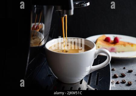 A hot espresso coffee being poured into a white mug Banque D'Images