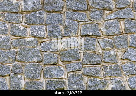 La texture d'un mur en pierre fait de pavés de granit immuré. Banque D'Images