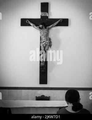 A vertical grayscale shot of a cross in a church of Rio de Janeiro, Brazil Stock Photo