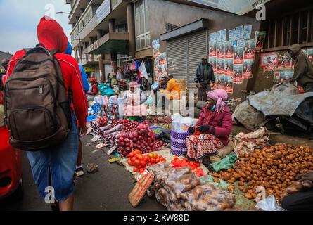 Les piétons marchent devant des colporteurs qui vendent leurs produits dans les rues du quartier central des affaires de Nairobi, au Kenya. La plupart des écoles kenyanes étaient sur Augus Banque D'Images