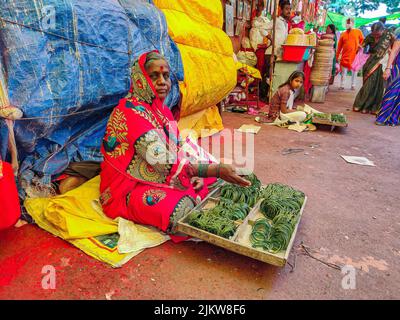 Tuljapur, Inde- 19 décembre 2019; photo de la famille des femmes indiennes de 50 à 60 ans portant une saree rouge, vendant des bannis en verre traditionnel de couleur verte Banque D'Images