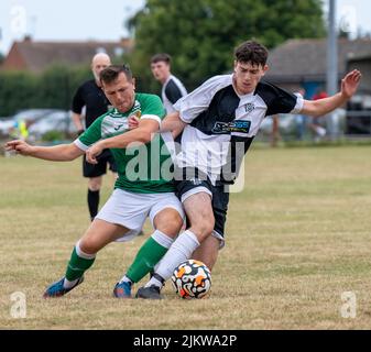 Action d'un match d'échauffement amical d'avant-saison entre East Preston FC et Moneyfields Reserve. Deux joueurs entrent en contact lorsqu'ils s'attaquent au ballon Banque D'Images