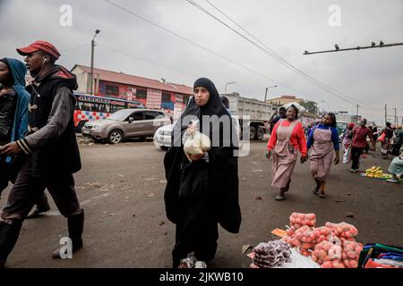 Les piétons marchent devant des colporteurs qui vendent leurs produits dans les rues du quartier central des affaires de Nairobi, au Kenya. La plupart des écoles kenyanes étaient sur Augus Banque D'Images