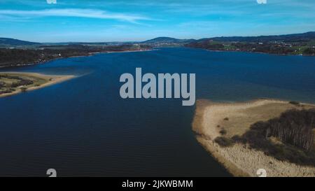 Un magnifique paysage marin entouré de champs verdoyants en arrière-plan des montagnes Banque D'Images