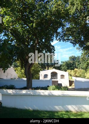 Photo verticale d'un ancien bâtiment blanc entouré d'arbres verts dans SUID-AGTER-Paarl Banque D'Images