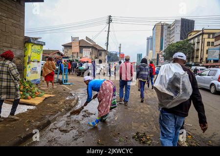 Les piétons marchent devant des colporteurs qui vendent leurs produits dans les rues du quartier central des affaires de Nairobi, au Kenya. La plupart des écoles kenyanes étaient sur Augus Banque D'Images