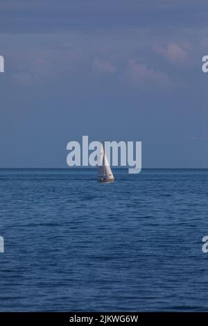 A vertical shot of a sail ship in the sea. Stock Photo