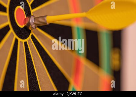 A closeup shot of a magnetic yellow dart on a dartboard Stock Photo