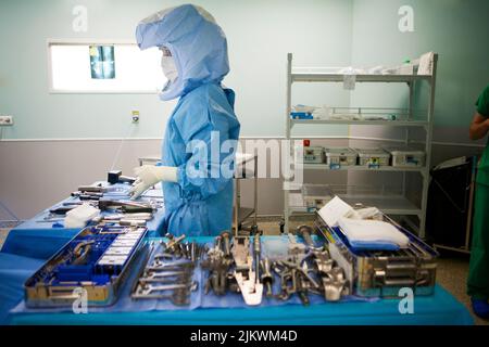 Chirurgie orthopédique, une infirmière prépare les instruments chirurgicaux pour l'installation d'une prothèse de genou. Banque D'Images