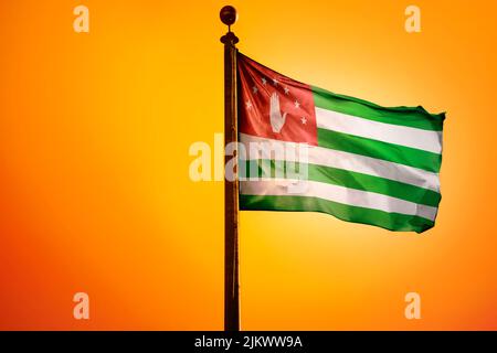 Illustration numérique du drapeau de la République d'Abkhazie agitant contre un ciel jaune vif Banque D'Images