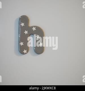 A cardboard lowercase letter 'h' with asterisks on a gray background Stock Photo