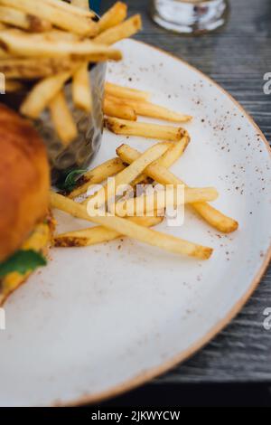 shoestring French fries on plate with burger at outdoor restaurant Stock Photo