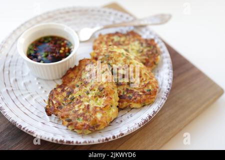 Beignets de courgettes, beignets de courgettes végétariennes sur une assiette blanche, servis avec de la sauce soja dans un petit bol blanc. Plats végétariens Banque D'Images