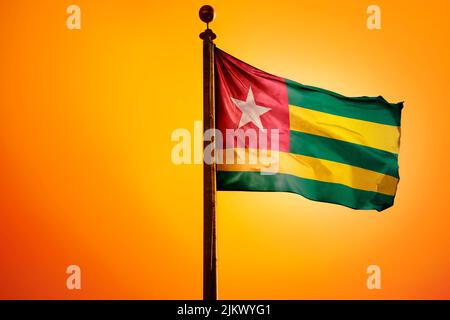 A 3D rendering of the Togo flag waving in the wind with an orange background Stock Photo